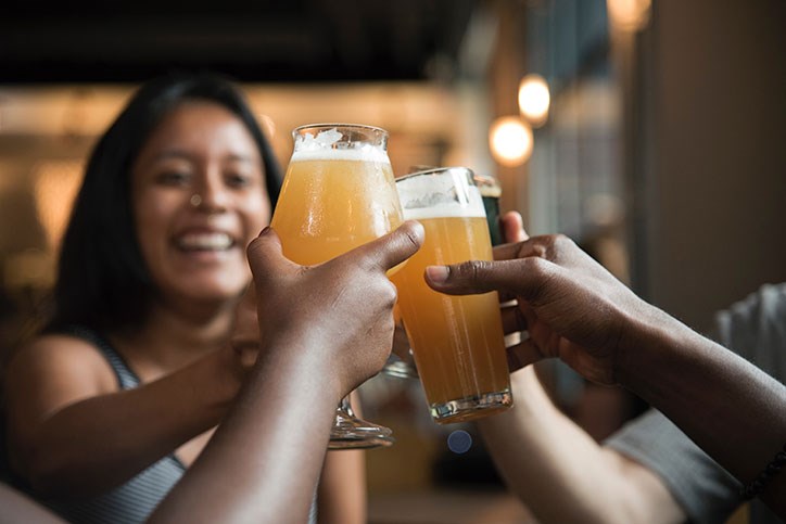 Young professionals toasting with glasses of beer.