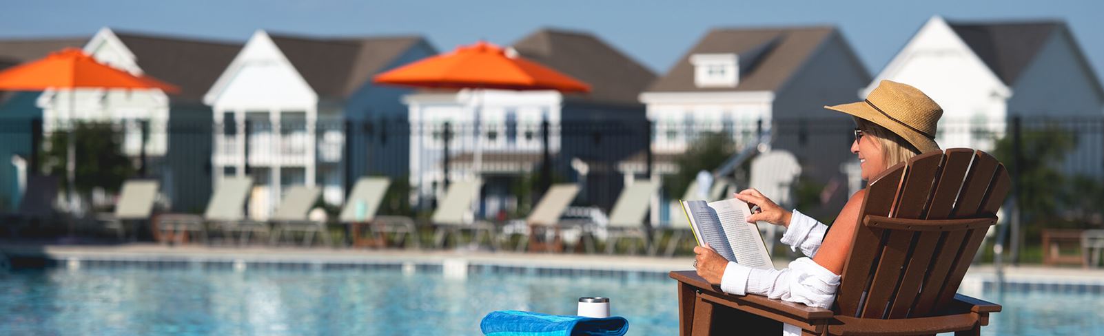 Woman reading by pool in Riverlights community in Wilmington, NC